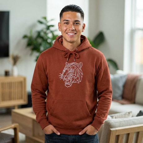 Man wearing a brown hoodie with a tiger design in a living room.
