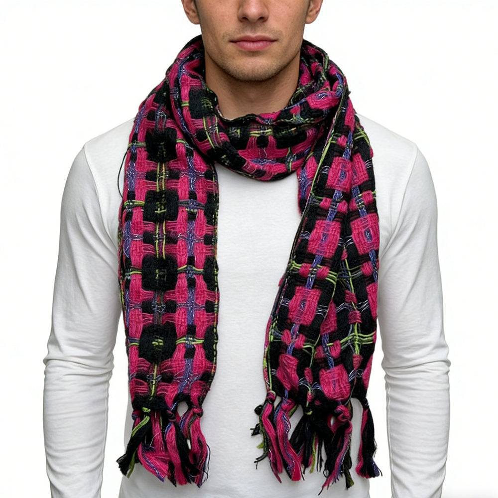 A stylish close-up of a man wearing a vibrant woven scarf with a bold geometric pattern in pink, black, and green tones, paired with a plain white long-sleeve shirt, showcasing a cozy and fashionable winter accessory. | PicSEO 1775591661754